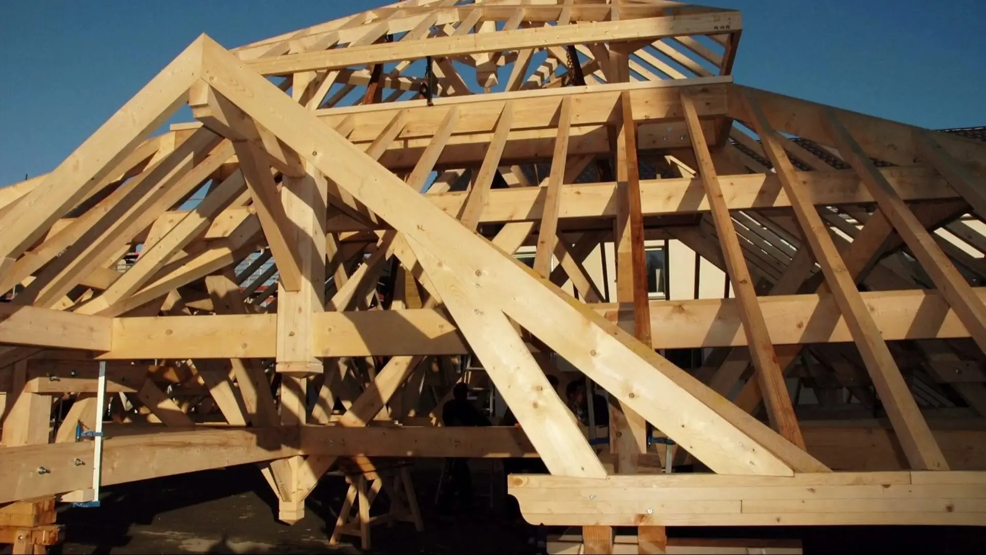 Charpente pyramidale en bois assemblée au sol avant le levage.