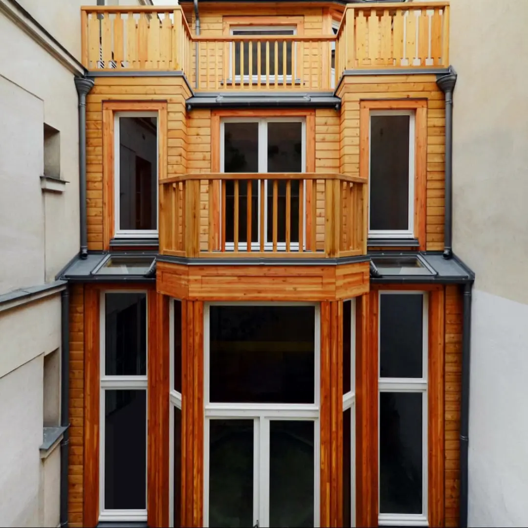 Façade en bois d’une maison à ossature bois de trois niveaux, entre deux immeubles parisiens.